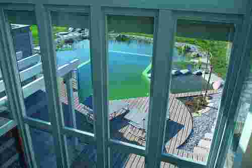 Naturhaus - Ausblick auf Pool und Garten durch Fensterfront