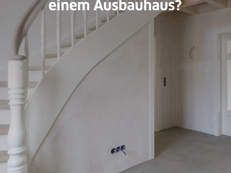 Innenansicht eines Stommel Hauses im Ausbauhaus-Zustand. Die geschwungene Holztreppe ist montiert, Wände und Decken sind vorbereitet, Bodenbeläge und finale Ausstattungen fehlen noch.