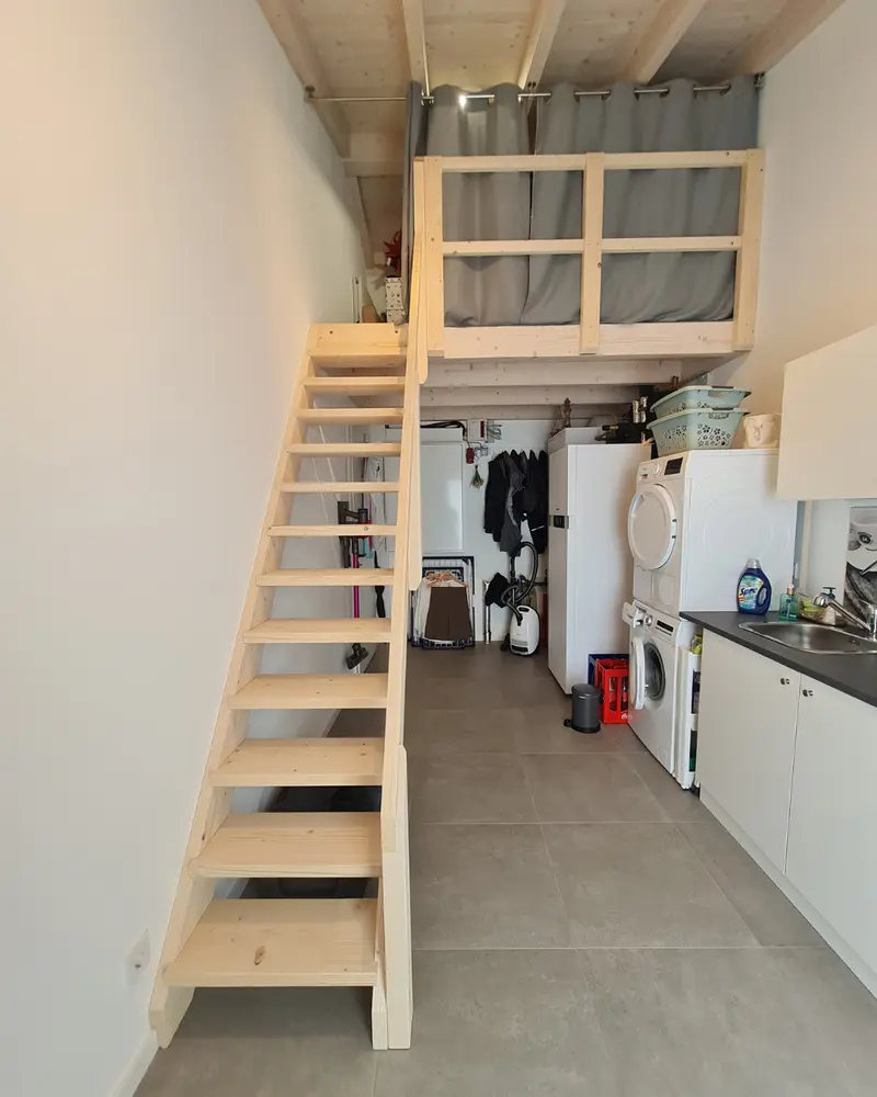 Fertiger Hauswirtschaftsraum mit Treppe, Waschmaschine, Spüle, Technikschrank und sichtbarer Nutzung der geplanten Anschlüsse im Alltag.