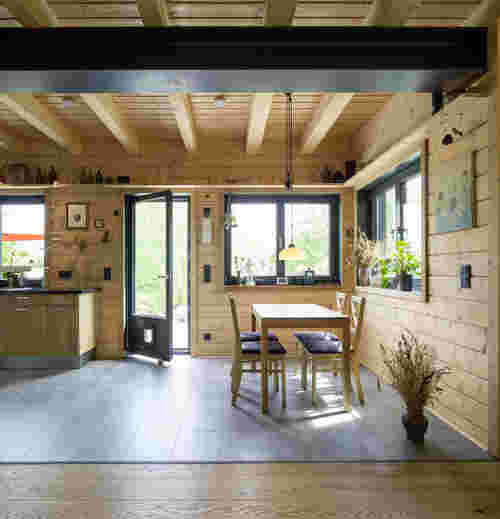 Naturhaus - offene Küche und Esszimmer mit Pflanzen und großen Fenstern 